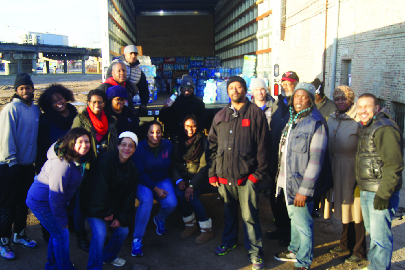 At 7:00 in the morning, Harmony Church Bottled Water drive secures donated water loaded by volunteers with Senior Pastor James Brooks, 24th Ward Alderman Michael Scott Jr, UIC Public Health students and other volunteers.